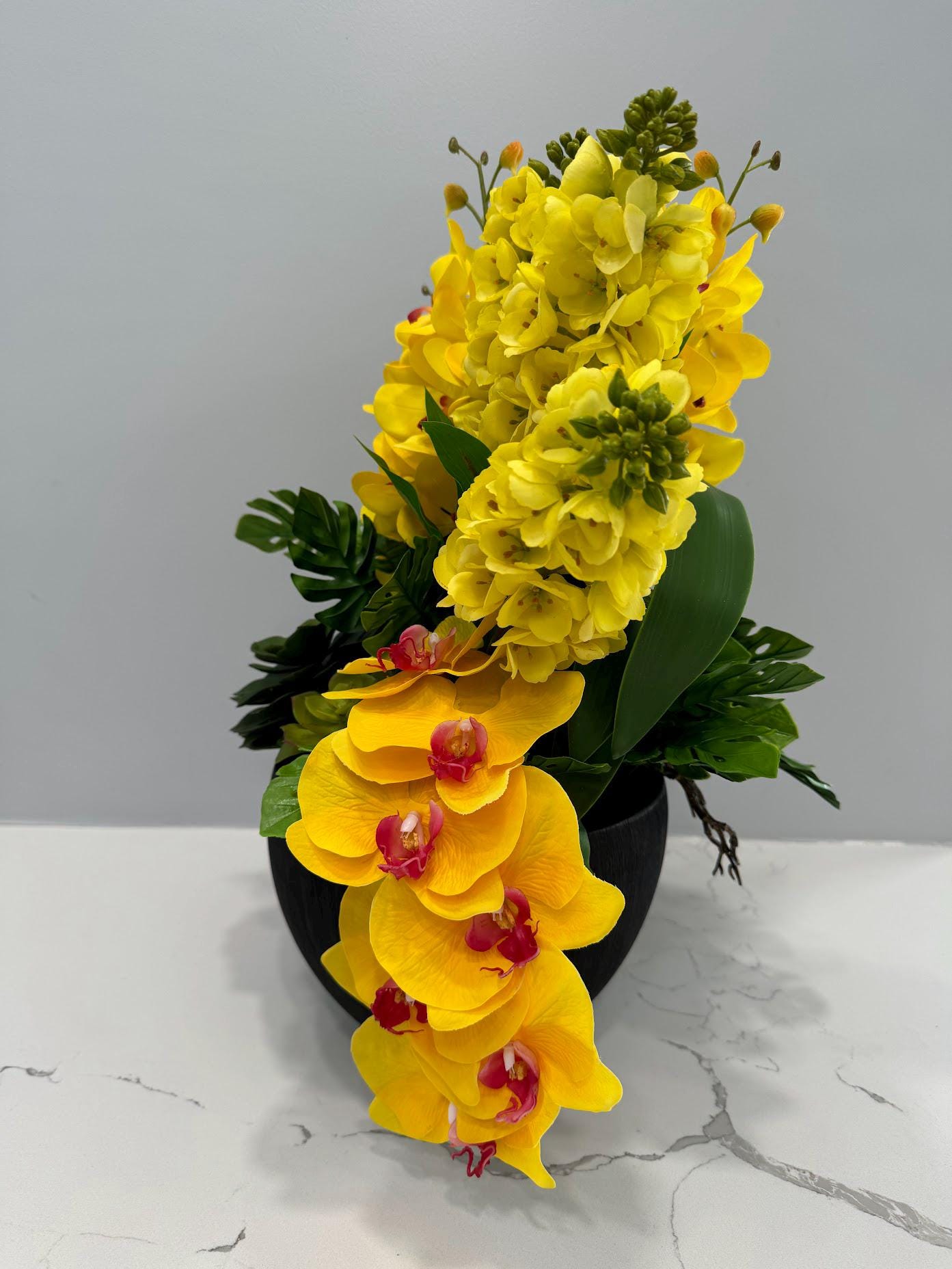 YELLOW ORCHIDS IN BLACK VASE