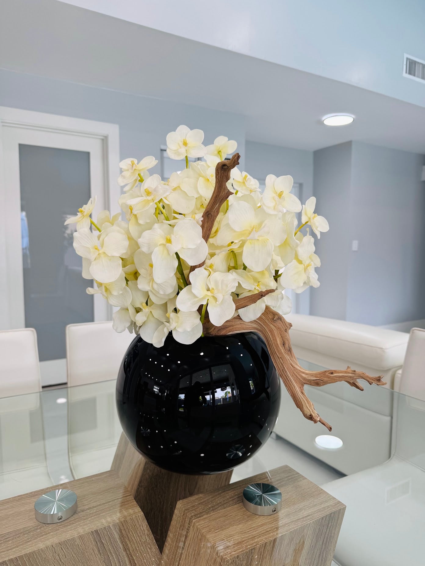 WHITE ORCHID DRIFTWOOD ARRANGEMENT IN BLACK GLOBE VASE