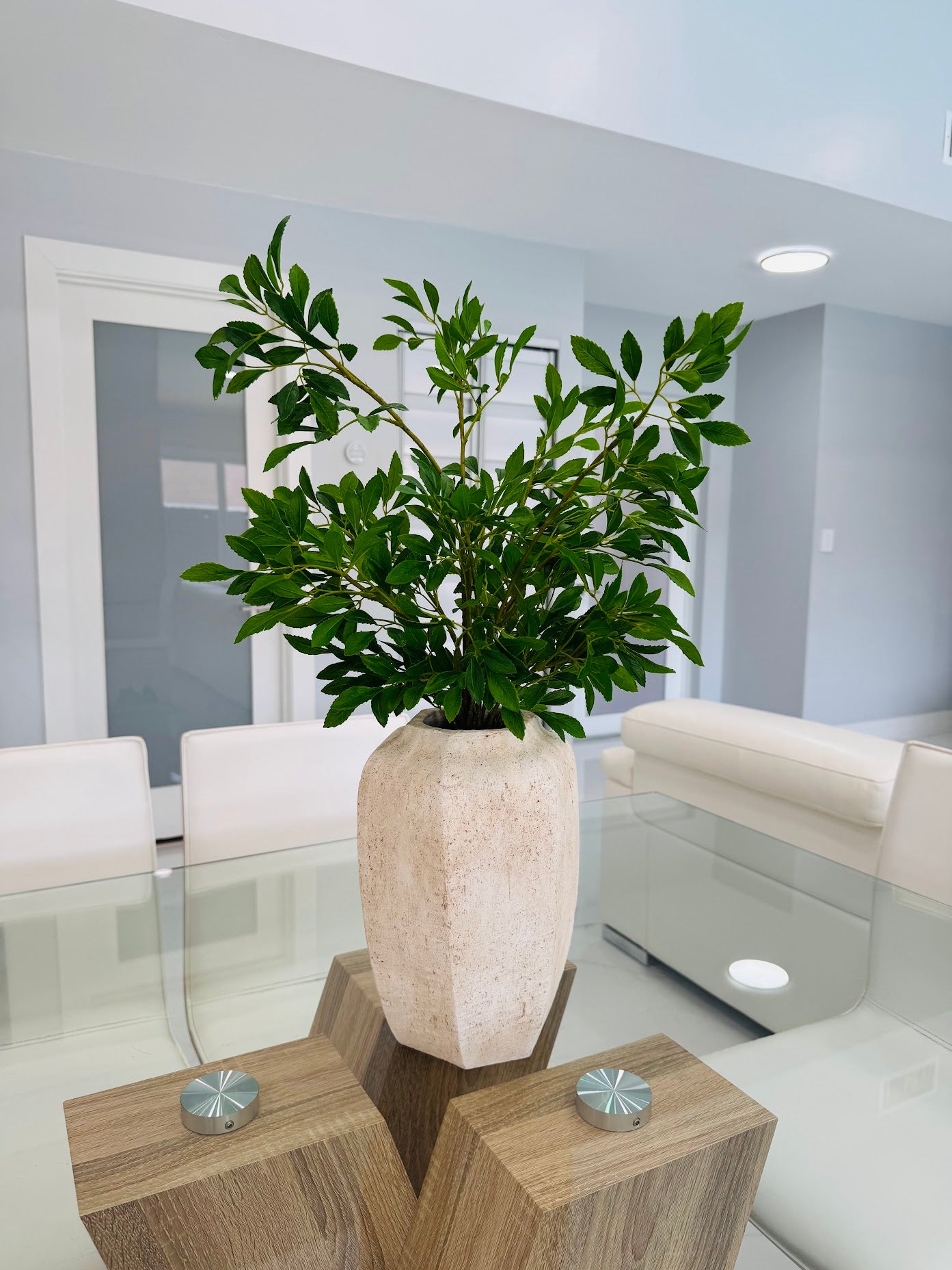 GREEN FOLIAGE ARRANGEMENT IN TEXTURED STONE VASE